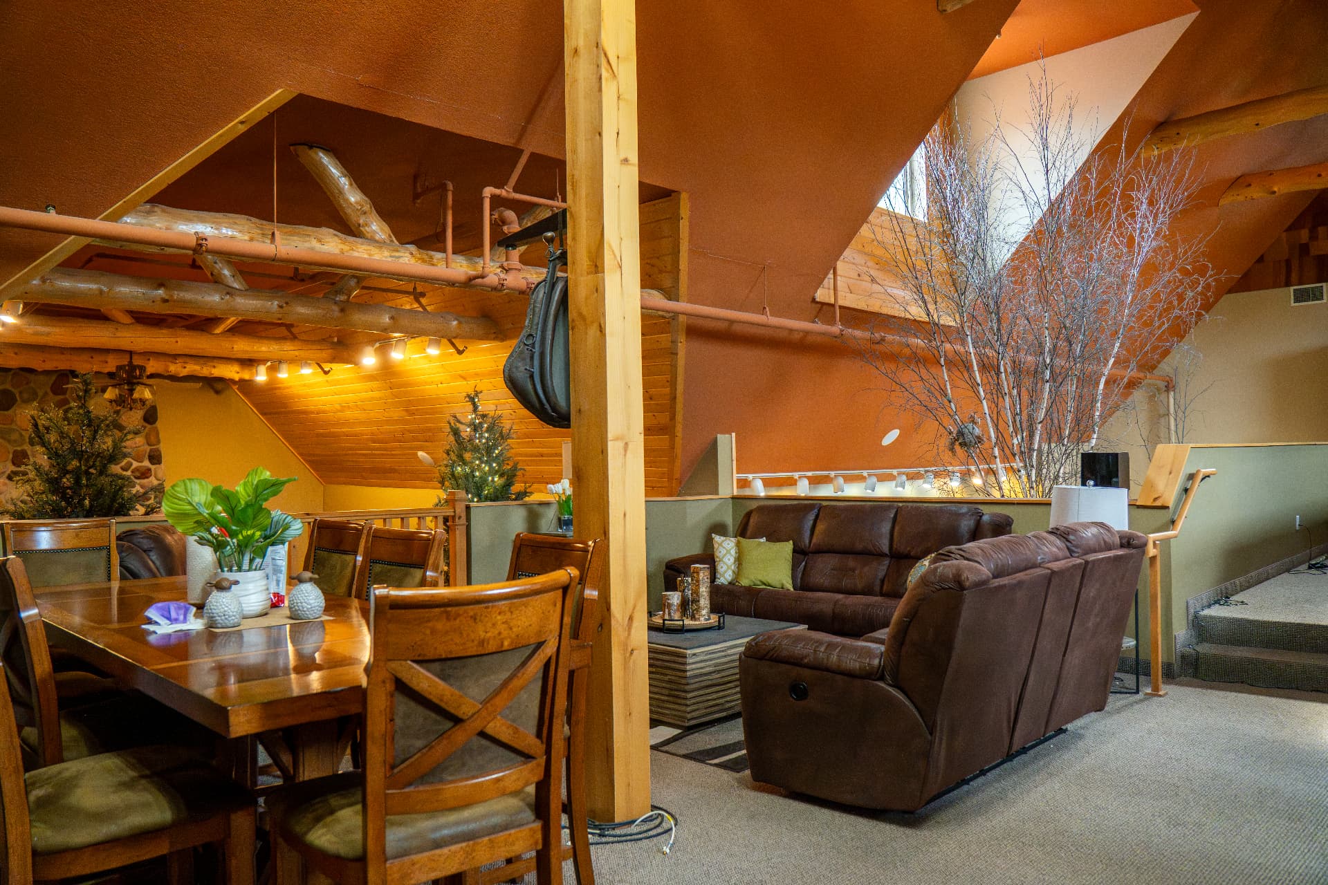 21. The loft dining area and table beneath the timber trusses.